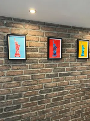 a brick wall with four framed pictures on it at loft riviera in Nice