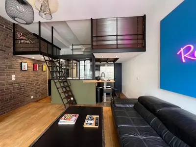a living room with a black couch and a loft at loft riviera in Nice