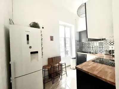 a kitchen with a white refrigerator and some bar stools at Cosy Family trip in Nice