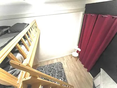 a bedroom with a bunk bed and a red curtain at Cosy Family trip in Nice