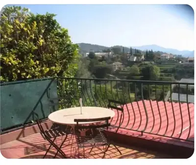 a table and chairs sitting on a balcony at Chambre au calme sur les collines in Nice
