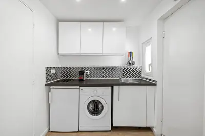 a white kitchen with a washing machine and a sink at Nice Renting - PENCHIENATTI - Chic & Modern Urban Pearl Massena Old Nice in Nice
