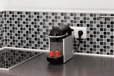a hair dryer in a bathroom with black and white tiles at Nice Renting - PENCHIENATTI - Chic & Modern Urban Pearl Massena Old Nice in Nice