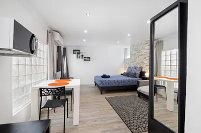 a living room with a table and a couch at Nice Renting - PENCHIENATTI - Chic & Modern Urban Pearl Massena Old Nice in Nice