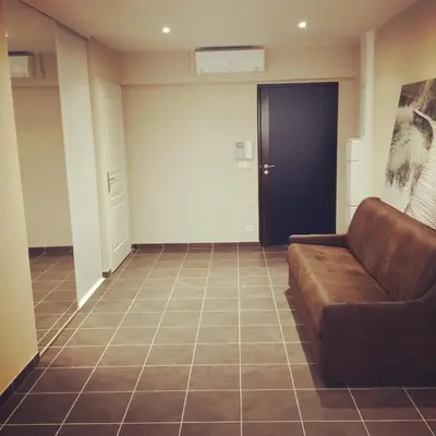 a living room with a couch and a door at Villa Serafina Apartements in Nice