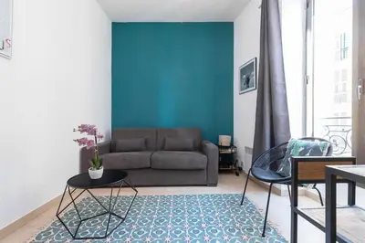 a living room with a couch and a blue wall at Superbe studio Nice hyper centre immeuble standing in Nice