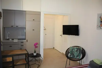 a living room with a table and a kitchen at Superbe studio Nice hyper centre immeuble standing in Nice