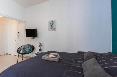 a bedroom with a bed with a couch and a chair at Superbe studio Nice hyper centre immeuble standing in Nice