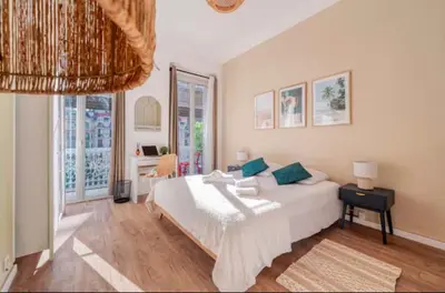 a bedroom with a large white bed with blue pillows at Guest House Chez Bastien in Nice