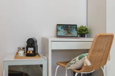 a desk with a laptop on it next to a chair at Guest House Chez Bastien in Nice