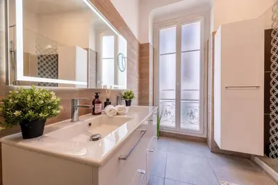 a bathroom with a sink and a large mirror at Guest House Chez Bastien in Nice