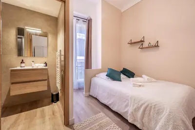 a bedroom with a bed and a sink and a mirror at Guest House Chez Bastien in Nice