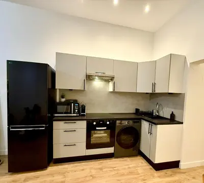 a kitchen with white cabinets and a dishwasher at Magnifique 2 pièces - Vieux Nice in Nice