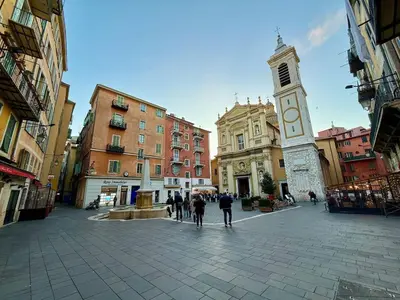 a group of people walking down a street with a clock tower at Magnifique 2 pièces - Vieux Nice in Nice