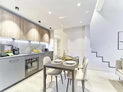 a kitchen and dining room with a table and chairs at Hyper Centre - Charming duplex - Luxury - Reversible air conditioning - 10 mins from Place MASSENA in Nice