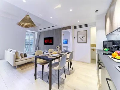a kitchen and living room with a table and chairs at Hyper Centre - Charming duplex - Luxury - Reversible air conditioning - 10 mins from Place MASSENA in Nice