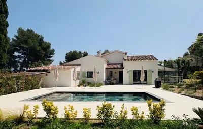 a villa with a swimming pool in front of a house at L'Esprit Sud, 4 Suites & Piscine Chauffée in Vence