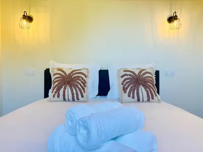 a white bed with two blue towels on it at L'Esprit Sud, 4 Suites & Piscine Chauffée in Vence