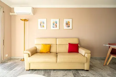 a living room with a couch with three colorful pillows at Sea & City View in Nice