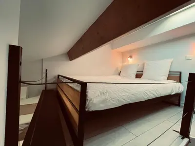 a bedroom with a bed with a wooden frame at Duplex Élégant au Cœur de Nice in Nice