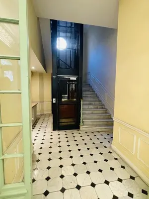 a hallway with a black door and a tiled floor at Duplex Élégant au Cœur de Nice in Nice
