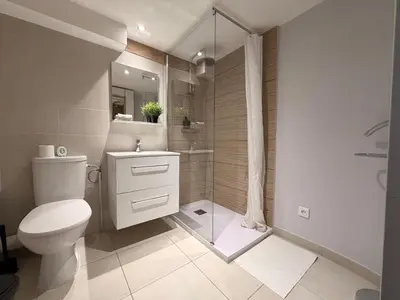 a white bathroom with a toilet and a shower at Duplex Élégant au Cœur de Nice in Nice
