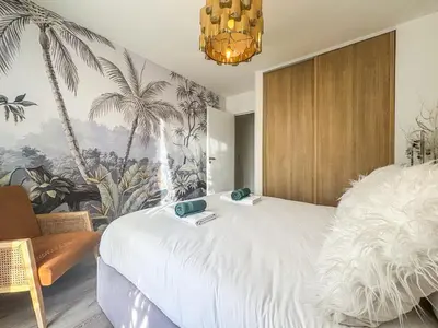 a bedroom with a large white bed and a chandelier at Evasion vue mer - Wifi, Piscine, Parking, 4pers in Nice