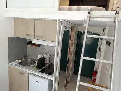 a small kitchen with a sink and a bunk bed at Studio climatisé in Nice