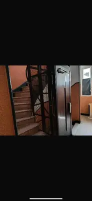 a staircase with a metal railing and a metal refrigerator at Studio climatisé in Nice