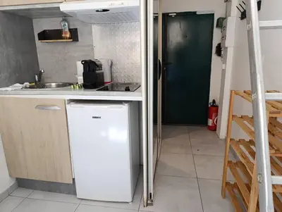 a small kitchen with a refrigerator and a sink at Studio climatisé in Nice