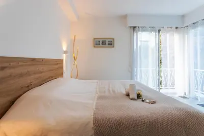 a bedroom with a large bed with a large window at LE SAINT ESTEVE AP4435 By Riviera Holiday Homes in Villefranche-sur-Mer