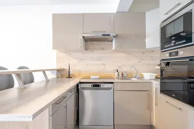 a kitchen with white cabinets and a stainless steel dishwasher at Superbe 3 pieces Nice 100m de la mer in Nice