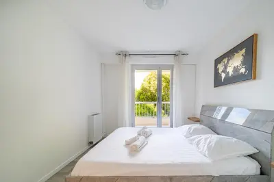 a white bed with a stuffed animal on top of it at Superbe 3 pieces Nice 100m de la mer in Nice