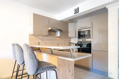 a kitchen with a wooden table and two chairs at Superbe 3 pieces Nice 100m de la mer in Nice