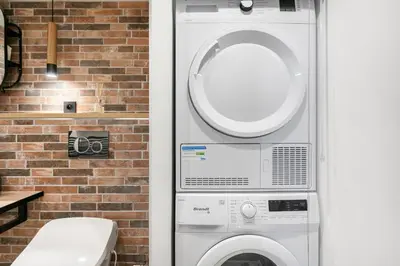 a washer and dryer next to a brick wall at Loft Industriel avec Terrasse et Filet Suspendu à Nice Cimiez in Nice