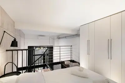 a bedroom with a white bed and a balcony at Loft Industriel avec Terrasse et Filet Suspendu à Nice Cimiez in Nice
