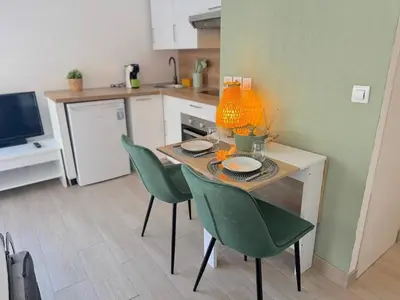 a kitchen with a table with green chairs and a kitchen with at ⁂ Calme et ensoleillé balcon quartier Port Nice in Nice