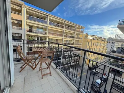 a balcony with a table and chairs and a building at ⁂ Calme et ensoleillé balcon quartier Port Nice in Nice