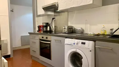 a white kitchen with a washing machine in it at ApartHotel Riviera - COCON BARILLERIE - Old Town - Promenade des Anglais in Nice