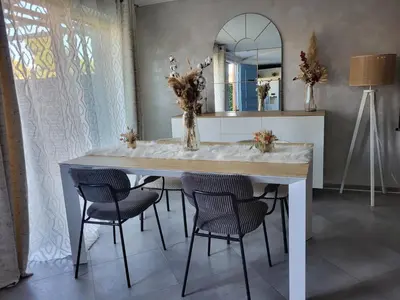 a dining room table with chairs and a mirror at Maison entre mer et montagnes in La Gaude