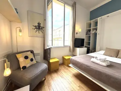 a bedroom with a bed and a chair at ApartHotel Riviera - LE COCON DE VICTOR - Grimaldi - Promenade des Anglais in Nice