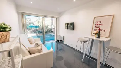 a living room with a white couch and a table at Superbe studio front de mer in Saint-Laurent-du-Var