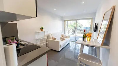 a kitchen and living room with a couch and a table at Superbe studio front de mer in Saint-Laurent-du-Var