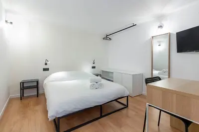 a white bedroom with a white bed and a desk at Loft Spacieux pour 10 personnes avec Terrasse in Nice