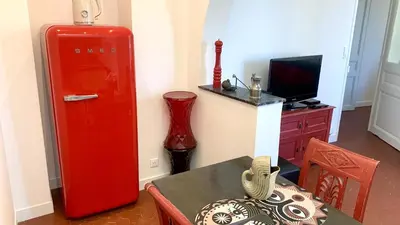 a room with an old red refrigerator and a table at ApartHotel Riviera - CLOCHER D'ALEXANDRE - Old Town - Promenade des Anglais in Nice