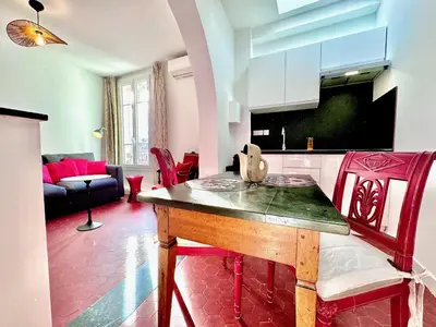 a kitchen and living room with a table and a couch at ApartHotel Riviera - CLOCHER D'ALEXANDRE - Old Town - Promenade des Anglais in Nice