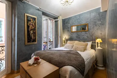 a bedroom with a large bed with a wooden table at HEAVEN AP4440 By Riviera Holiday Homes in Villefranche-sur-Mer