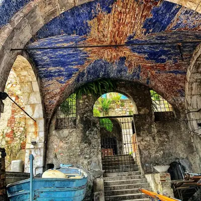 an old building with stairs and a blue boat at HEAVEN AP4440 By Riviera Holiday Homes in Villefranche-sur-Mer