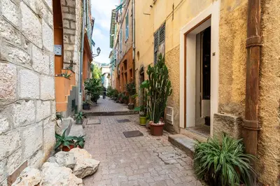 an alley with potted plants in an alley between buildings at HEAVEN AP4440 By Riviera Holiday Homes in Villefranche-sur-Mer