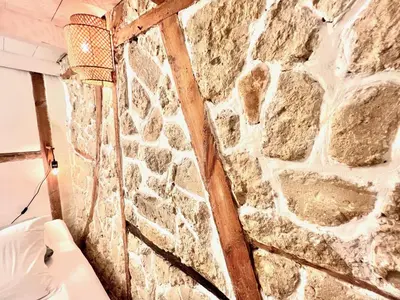 a stone wall in a room with a couch at ApartHotel Riviera - MAISON DU CHATEAU - Old town - Promenade des Anglais in Nice